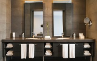 Luxurious bathroom with elegant sinks, adorned with stylish fixtures, and complemented by two large mirrors, creating a sophisticated and visually appealing space.