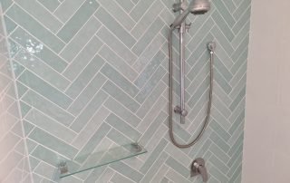 Green herringbone tiled shower